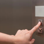 Iemand drukt liftknop in van huislift