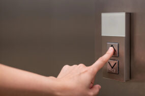 Iemand drukt liftknop in van huislift