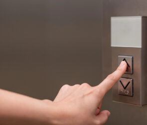 Iemand drukt liftknop in van huislift