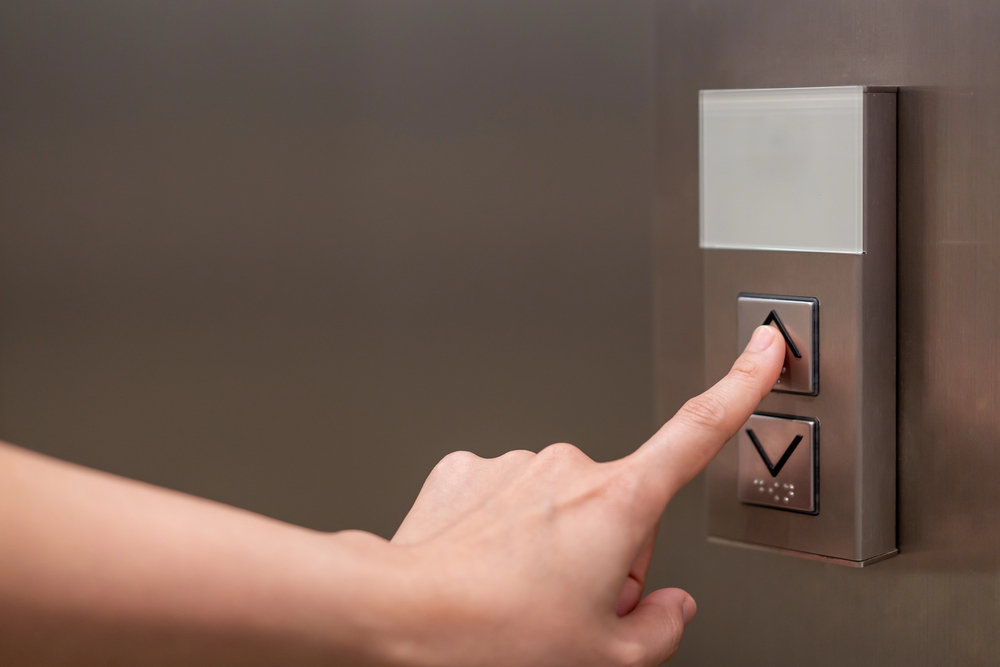 Iemand drukt liftknop in van huislift